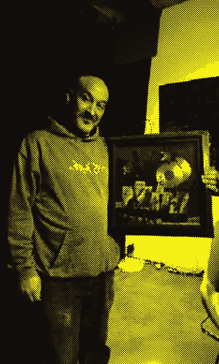 Un membre de l'association tient un disque d'or encadré